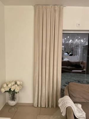 Beige sammetsgardin med veck - Säljer en elegant beige gardin i sammetsliknande material med fina veck. Gardinen är lång och hänger från tak till golv, vilket ger ett lyxigt intryck till rummet. Längd 265cm och bred 75cm, det är sex av dem och en kostar 250kr. 