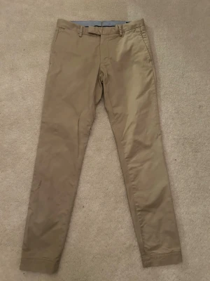 Beiga Ralph Lauren chinos  - Snygga beiga chinos med slim fit och klassisk design. Stl 29/32 i väldigt fint skick. Hör av er vid frågor. Pris kan diskuteras vid snabb affär. 