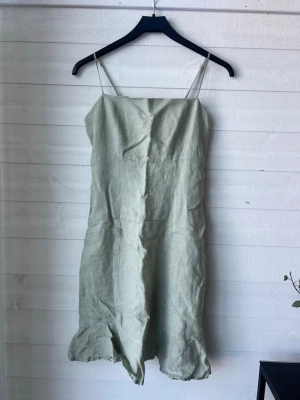 Ljusgrön linnéklänning med smala band - Säljer en grön linne klänning från Gina. Den är endast använd några gånger och är i storlek M💕