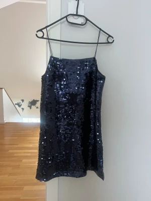 Mörkblå paljettklänning med smala band - Säljer en kort marinblå paljett klänning från HM. Klänningen är i storlek S och endast använd två gånger💕skriv för mer info