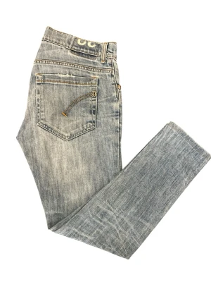 Ljusblå jeans från Dondup Jeans - Säljer ett par ljusblå jeans från Nudie Jeans med klassisk femficksmodell och dragkedjedetalj på bakfickan. Jeansen har en rak passform och är tillverkade i mjuk denim. Snygg slitning och diskreta detaljer gör dem perfekta till din vardagsstil. Modellen är 167!! Hör av er via funderingar!