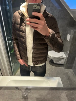 Brun dunjacka  - Riktigt schysst dunjacka i snygg brun färg passar perfekt ull våren. Jackan är i riktigt bra skick. Jag på bilden är 188cm och bär storlek S vilket är för lite på mig. Hör gärna av dig vid frågor:)