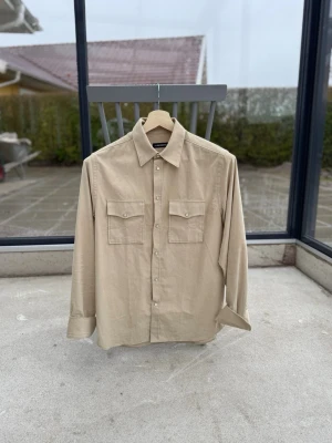 J.Lindeberg Overshirt - Modell ”Carlos”. Beige färg, kvitto och tag borde finnas, hör av er vid frågor isåfall. Knappt använd, som ny. Extra knapper följder med. I Manchester matrial. Passar bra för längder runt 175-185, vikter 65-80 pannor om jag fick uppskatta. Ganska rak cut (passform). Man kan enkelt ha 1-2 lager under om så önskas. 