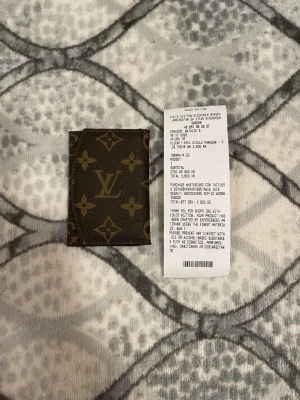 Louis Vuitton monogram plånbok - Säljer en klassisk brun plånbok från Louis Vuitton med det ikoniska monogrammönstret i beige. Plånboken är tillverkad i tåligt canvasmaterial och har en smidig, fyrkantig form som passar perfekt för kort och sedlar. Perfekt accessoar för dig som gillar lyxiga detaljer.