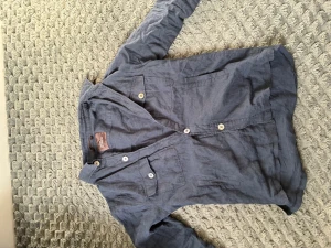 Blå linneskjorta från Oscar Jacobson - Snygg blå skjorta i linne med två bröstfickor och vita knappar. Skjortan har klassisk krage och lång ärm, perfekt för en avslappnad men stilren look. Materialet är luftigt och ger en skön känsla.