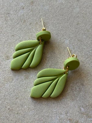 Handgjorda örhängen i grönt – blad med guldfärgade detaljer - Handgjorda örhängen i polymerlera 3,5cm  Enkla och stilrena blad i grönt med guldfärgade detaljer.  Lätta att bära och passar både till vardag och fest.  Antiallergiska detaljer Lätta Guldfärgade detaljer Flera par finns  Skriv om du vill se exakt par innan köp  Skickas