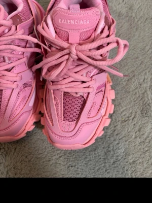 Balenciaga rosa sneakers Track - Riktigt feta rosa sneakers från Balenciaga, modell Track. Skorna har chunky sula, mesh och läderdetaljer samt kraftiga snören. Perfekta för dig som vill sticka ut med en sportig och trendig look. Märkeslogga syns tydligt på plösen.