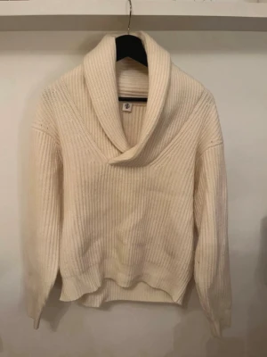 Vi stickad tröja - Vit stickad tröja med trevlig krage. Liliten fläck på underarmen som knappt syns.