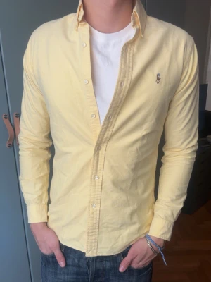 Gul skjorta från Polo Ralph Lauren - Skjorta från Ralph Lauren, inga defekter. Modellen är 187 cm, väger 80 kg och brukar klä i M.   Storlek på skjorta S/P  Mått -|-  Axelmått: 42 cm  Längd: 70 cm  Byst: 52 cm  Armar: 62 cm   Leverans sker dagen efter senast. Skriv om du har nån fråga✨