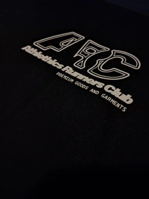 Svart t-shirt ARC  - Svart t-shirt från H&M med trycket 'ARC Athletics Runners Club' i vitt på bröstet. Klassisk rund halsringning och korta ärmar. Perfekt för en sportig och avslappnad stil.