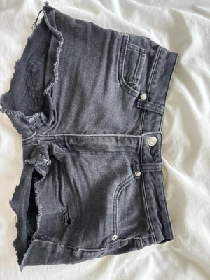 Shorts med låg midja vintage 💋 - Snygga grå jeansshorts med fransiga knaster. Midjemått 33cm, grenhöjden 21cm❣️