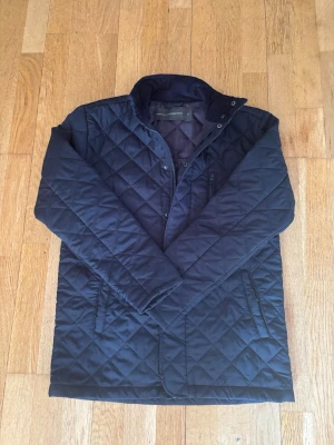 French connect Jacka - Stilren svart/Mörkblå quiltad jacka från French Connection med lite högre krage och dragkedja samt knappar framtill. Storlek S. Jackan har bara använts en gång.  Pris kan diskuteras. 