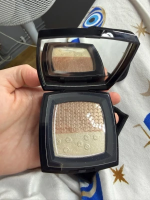 Chanel highlighter duo i guld & brons - Limited edition!Lyxig highlighter från Chanel med två nyanser – en skimrande guldig och en bronzig ton. Kommer i en elegant svart dosa med spegel och tillhörande borste. Perfekt för att ge glow och highlighta ansiktet. Klassisk Chanel-logga på locket. Med original box