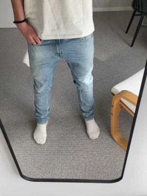 Ljusblå jeans från Tiger of Sweden - Säljer ett par ljusblå jeans från Tiger of Sweden med klassisk femficksdesign och raka ben. Jeansen har normal passform och är tillverkade i bomull. Perfekta för dig som gillar en enkel och stilren look.