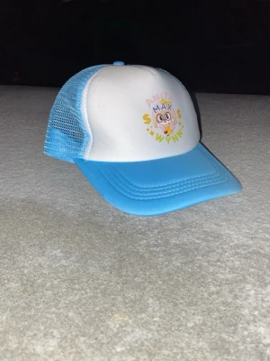 Blå och vit truckerkeps Anita Max wynn - Riktigt fet keps med tryck på framsidan som säger ”Anita Max Wynn”. Perfekt nu till våren och sommaren. Vid frågor är de bara skriva.