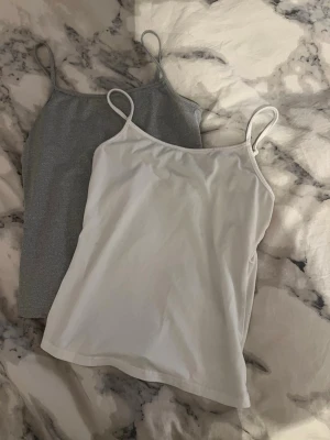 Två baslinnen i vitt och grått - Säljer två enkla linnetoppar med tunna axelband, en i vitt och en i grått. 