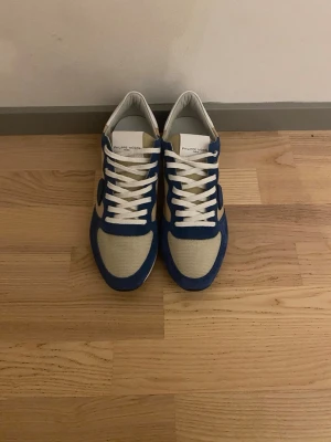 Blå och beige sneakers Philippe Model trainers - Snygga sneakers från Philippe Model i blått och beige med vita detaljer. Ovandelen är i mocka och mesh, med vita skosnören. Aldrig använda, bara uppackade. Tveka inte om du har någon fråga😀Priset är inte hugget i sten, skriv till mig så ska vi hitta en lösning som känns bra för oss båda😀😍 (passar storlek 42)