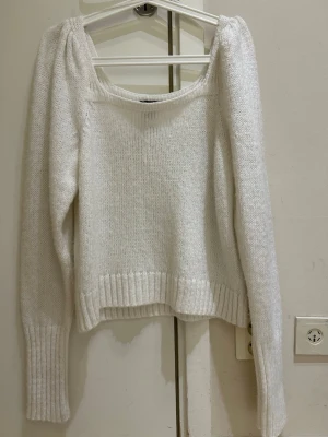  Ny Vit stickad tröja från Lindex - Mysig vit stickad tröja från Lindex med bred ribbad mudd vid ärmslut och nederkant. Tröjan har en något lös passform, rundad halsringning och långa ärmar. Perfekt för lager på lager och enkel att matcha till olika outfits.