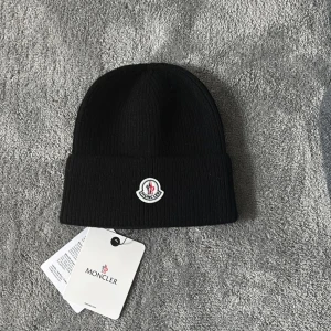 Moncler mössa - En svart mössa från moncler. HÖR AV DIG VID FUNDERINGAR!💸