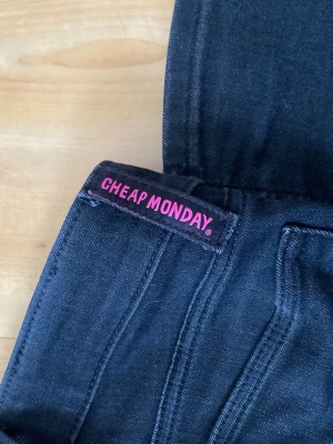 Svarta Cheap Monday jeans - Säljer ett par svarta jeans från Cheap Monday med klassisk femficksmodell och dragkedjegylf. 