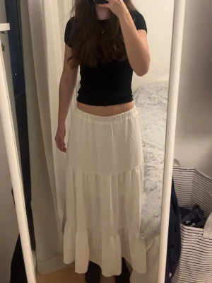 Vit långkjol med slits - En snygg vit flowig långkjol med slits, den har en resår i midjan vilket gör den veldigt stretchig. Jag är 173 cm, den passar perfekt till sommaren eller semester.🥰