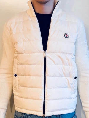 Moncler cardigan  - Säljer en helt ny vit/of-white cardigan i storlek medium. Jackan är aldrig använd! Den bärs som storlek S och är något tight runt armarna. Tags följer med på köpet.   Mått: Modellen på bilden är 180cm lång och väger knappa 70kg  Längd på jackan: 63cm från topp till botten Bredd, armhåla till armhåla: 53cm