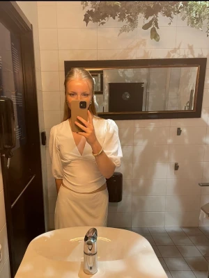 Vit omlottopp från Gina Tricot - Säljer en vit topp från Gina Tricot med v-ringning och trekvartsärm. 