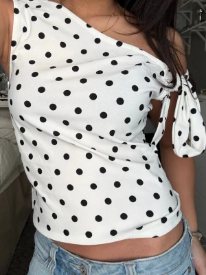 prickig topp - Säljer denna prickiga topp från Amisu med knyt bar arm på sidan i storlek M men den passar mig perfekt som bär XS/S🤗🥰🌸