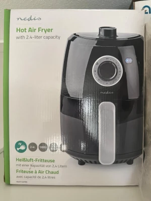 Nedis varmluftsfritös 2,4 liter - Säljer en svart varmluftsfritös från Nedis med kapacitet på 2,4 liter. Fritösen har en rund form, silverfärgad vred på framsidan och handtag i metall. Perfekt för att laga mat utan olja och enkel att använda i köket.