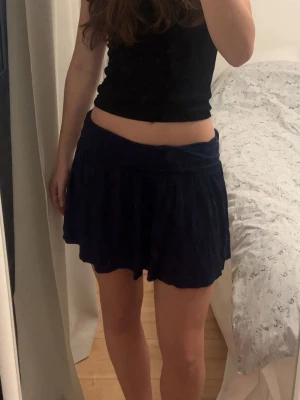 Matinblå minikjol - Snygg marinblå minikjol med en bredare resår i midjan och sen en mer flowig modell nertill. Den är lite insydd i midjan för att passa en storlek S men som storlek M i längd. Den passar perfekt till sommaren eller semester.🥰