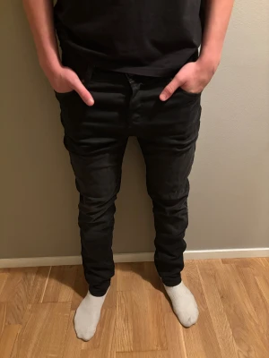 Svarta slim fit jeans från Jack & Jones - Svarta jeans från Jack & Jones. Jeansen har bälteshällor, knapp och dragkedja fram samt raka bakfickor. Materialet är jeans med stretch för extra komfort. Perfekt för dig som gillar en stilren och modern look. Hela jeans och inga skador storlek 30-31. Nypris 1000kr mitt pris 100kr priset kan diskuteras