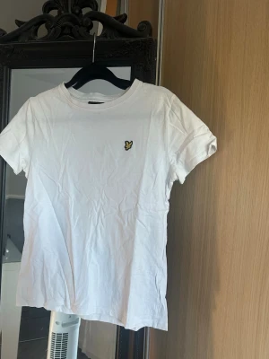 Vit t-shirt från Lyle & Scott - Vit t-shirt från Lyle & Scott med klassisk rund hals och korta ärmar. På bröstet är lyle & scott märket!🙂Har tyvärr blivit för liten för mig