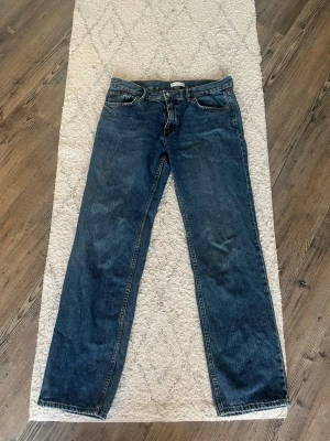 Mörkblå raka jeans - Säljer ett par klassiska mörkblå jeans med rak passform. Jeansen har fem fickor och normal midja. Tillverkade i slitstarkt denimtyg, perfekta för en avslappnad och tidlös look.