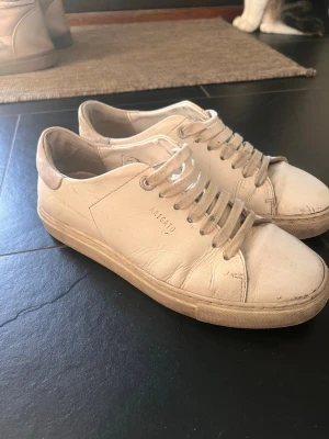 Vita sneakers från Axel Arigato - Stilrena vita sneakers från Axel Arigato med diskret logga på sidan. De har använts i ca 6 månader men inga skador på skorna, orginalpris 2650kr. Skriv privat för fler bilder