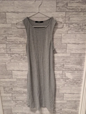 Grå ribbad klänning från Bik Bok - En enkel och stilren grå ribbad klänning från Bik Bok. Klänningen är ärmlös med rund halsringning och har en kroppsnära passform. Perfekt för en avslappnad och trendig look.