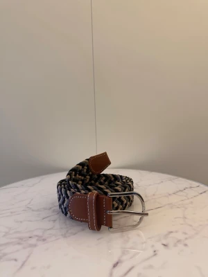 Svart grå beiget flätat bälte - Tja säljer helt nya svenska klassiska flätade bälten från Bältgallerian i storlek 105cm lång och 3,5cm bred. Dem är i ett elastiskt material och finns i flera olika färger i min profil