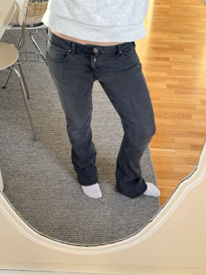 Svarta bootcut jeans med låg midja - Säljer ett par svarta bootcut jeans med låg midja i storlek 32. De är väldigt stretchiga vilket är väldigt skönt. Lite slitna längst ner som man ser på bilden💓