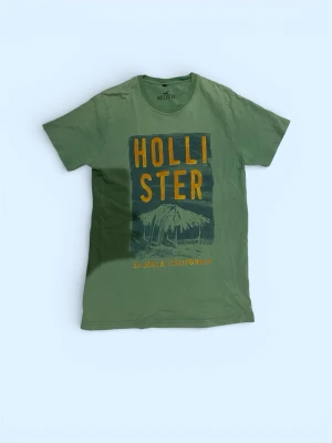 Grön Hollister t-shirt - Snygg grön t-shirt från Hollister. Ovanlig och eftertraktat. Skicket är mycket bra och storlek är M. Vid fler frågor är det bara att höra av er!