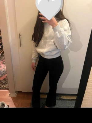 Svarta bootcut byxor från H&M Divided XS - Svarta bootcut byxor från H&M Divided i storlek XS. Byxorna har hög midja och är gjorda i ett stretchigt material med viskos, polyamid och elastan. Snygg passform som sitter tajt upptill och släpper ut vid bensluten.