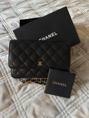 Handväska  - Svart handväska med guldiga detaljer. 