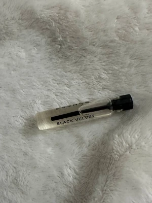 Black Velvet parfymprov essnce - Litet parfymprov av Black Velvet med genomskinlig glasflaska och svart plastkork. Perfekt att ha med i väskan för att testa en ny doft. Flaskan är smidig och stilren med enkel design.