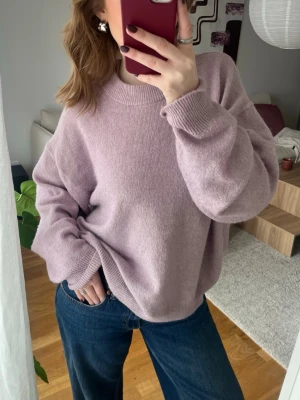 Ljuslila oversized stickad tröja - Mysig oversized stickad tröja i ljuslila med rund halsringning och breda ribbade muddar vid ärmslut och nederkant. Perfekt för lager på lager och en avslappnad look. Passar till både jeans och kjol.