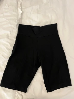 Svarta cykelshorts från Vero Moda - Svarta cykelshorts från Gina tricot, basically basics-kollektionen. De har hög midja och är tillverkade i mjuk bomull med stretch. Perfekta för en avslappnad och sportig stil.