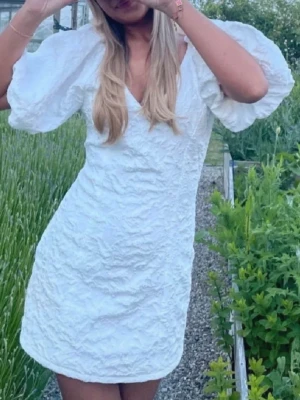 Vit studentklänning  - Oanvänd studentklänning från gina tricot. Dragkedja i bak. Väldigt fint tyg.