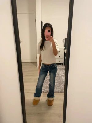 Lågmidjade jeans - Snygga blå bootcut jeans med låg midja. Jeansen har en tvättad look och raka ben som slutar i en liten utsvängning. Är lite slitna vid ändarna men det är inget som märks när man har på sig de. Passar mig bra som är 160cm och skulle säga storleken är Xs/S. Skriv för fler mått eller bilder. Priset kan diskuteras.