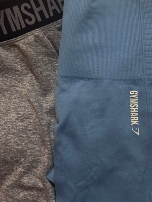 Leggins Gymshark - Säljer två par gymshark tights.                                  • Köp en 89kr • köp båda för 110kr. Det blåa paret har relativt hög midja och små mesh hål i sidan som kan göra att dom upplevs mer luftiga vid till exempel konditionsträning. Det gråa paret har lite lägre midja. Båda är i storlek S. Köp gärna bundles!