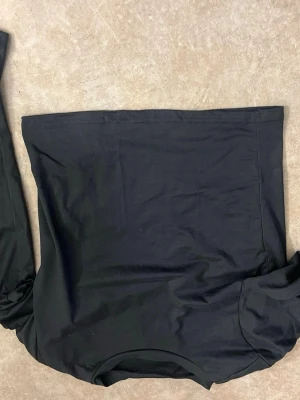 Grå långärmad topp - Snygg grå topp med långa ärmar. Perfekt för dig som vill ha en enkel men trendig look. Tillverkad i mjukt material som sitter skönt mot kroppen. Passar till många olika stilar och outfits.