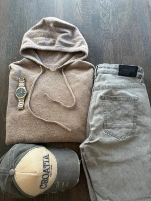 Hoodie I merino ull - Säljer en beige hoodie med merino ull vilket är väldigt likt Kashmir. Perfekt för dig som gillar en clean och avslappnad stil. Hoodien är i storlek S men skulle också passa XS. Passar både tjejer och killar. Tröjan har ett litet hål (se bild), detta syns inte när luvan hänger ner.
