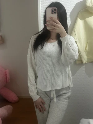Vit oversized stickad tröja - Säljer en vit, oversized stickad tröja med rund halsringning och långa ärmar. Tröjan har en avslappnad passform och ribbstickade muddar vid ärmsluten. Perfekt för en chill och stilren look.