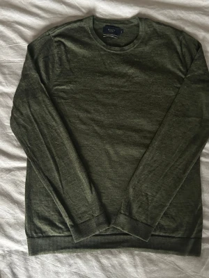 Mörkgrön stickad tröja från Riley - Riktigt schysst stickad tröja från Riley i mjuk och tunn merinoull🤩 perfekt för lager på lager🙌Har ett litet hål på baksidan vid ärmen men inget som syns när man har på sig den✔️ I övrigt så är det inga fler defekter! Skriv om ni har frågor📲🙏